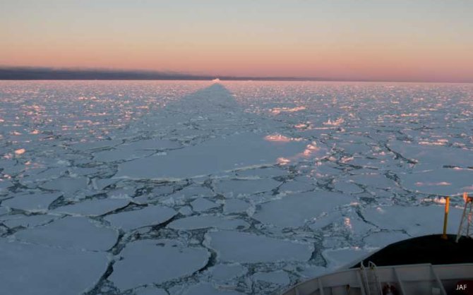 In the midnight sun, Polarstern casts it shadow over the ice to the horizon.
