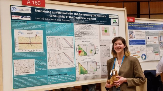 Luka staat naast haar werk over thermische profilering op het gebied van hydrogeologie
